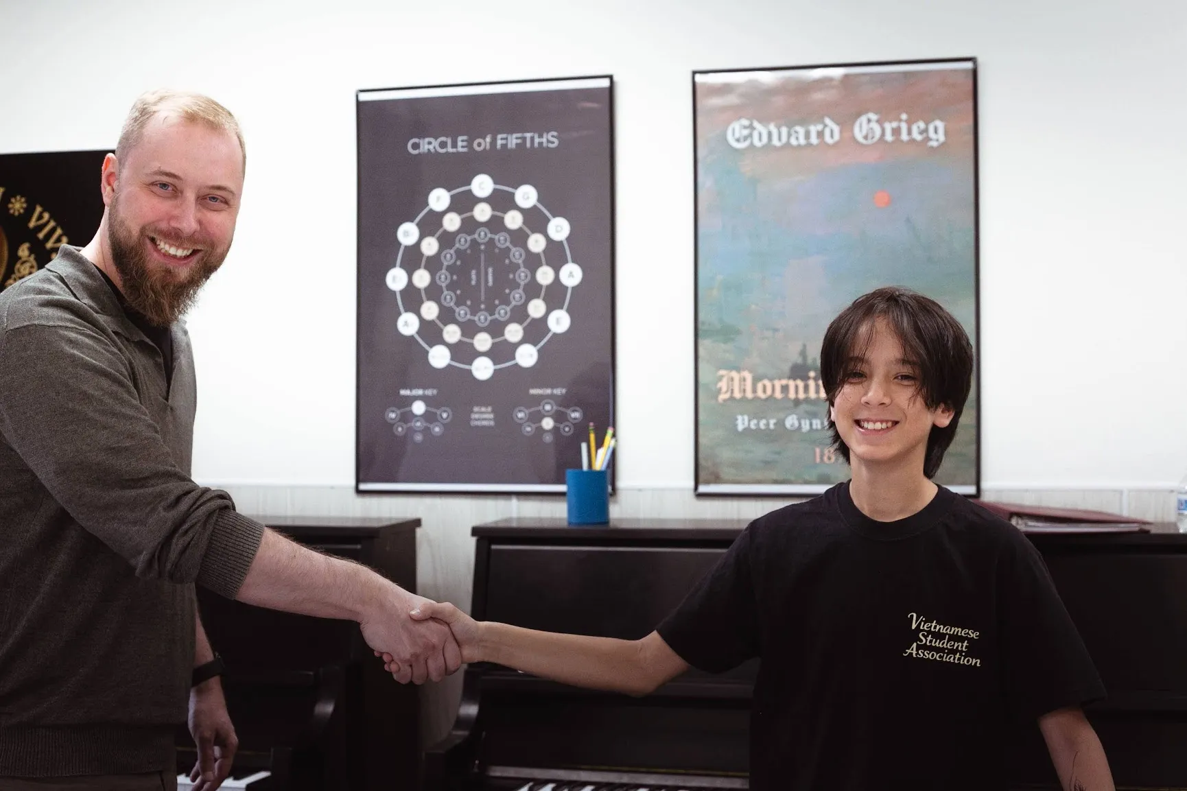 Piano teacher and student shaking hands after a trial lesson