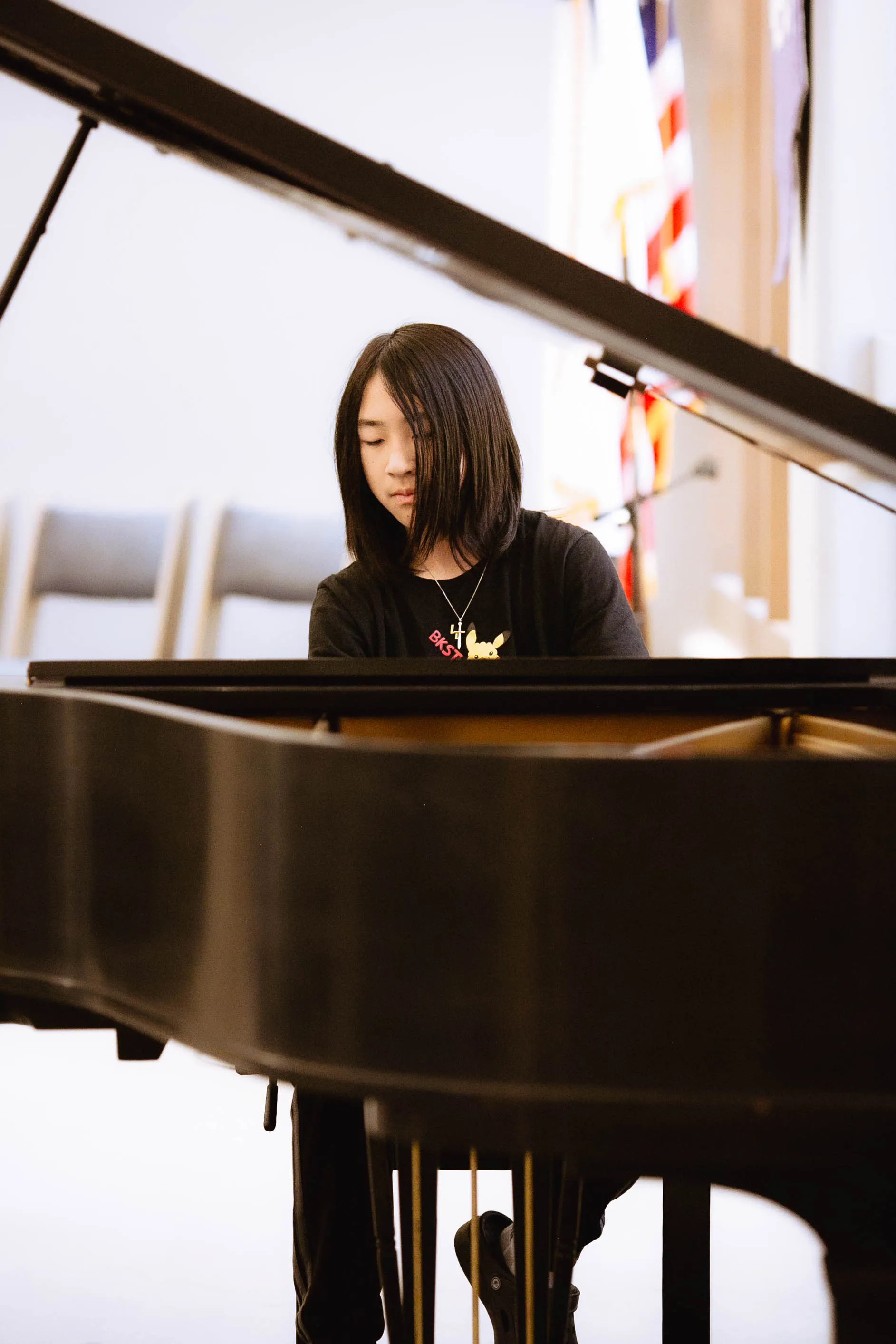 Student performing at a grand piano